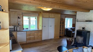Una cocina acogedora con armarios de madera, lavavajillas integrado y un comedor con mesa y sillas.
