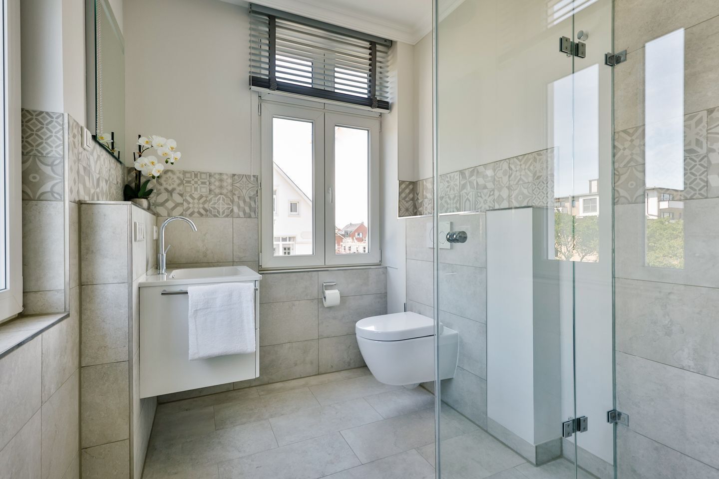 Ein modernes Badezimmer mit Toilette, Waschbecken und Duschkabine.