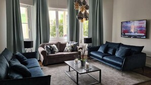 A modern living room with two sofas, a coffee table, and a TV on the wall. - A typical Cannes townhouse, 450 meters from the Croisette  (Cannes)
