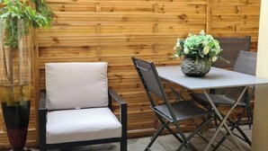 A patio area with a table and chairs, a potted plant, and a wooden fence. - A typical Cannes townhouse, 450 meters from the Croisette  (Cannes)