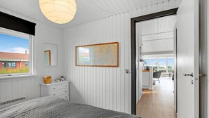 A bedroom with a bed, a dresser, a map on the wall, and a view of the outside. - Cozy home in Hurup Thy with WiFi (Hurup Thy)
