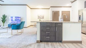 A modern kitchen with a central island, built-in cabinets, and a stainless steel refrigerator. - Boulevard Stays Charming 2BR, Parking (Middletown)