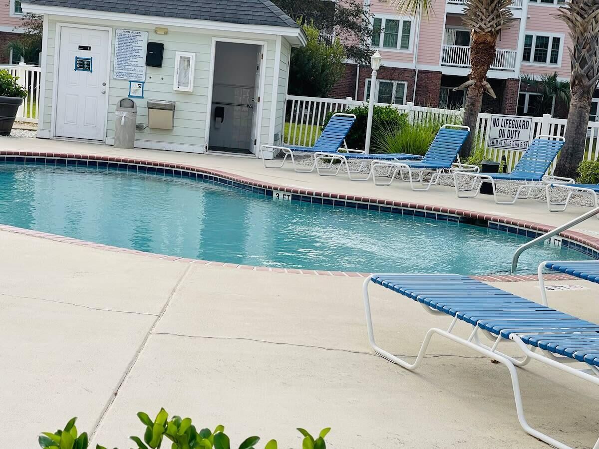 A swimming pool with lounge chairs and a lifeguard station.