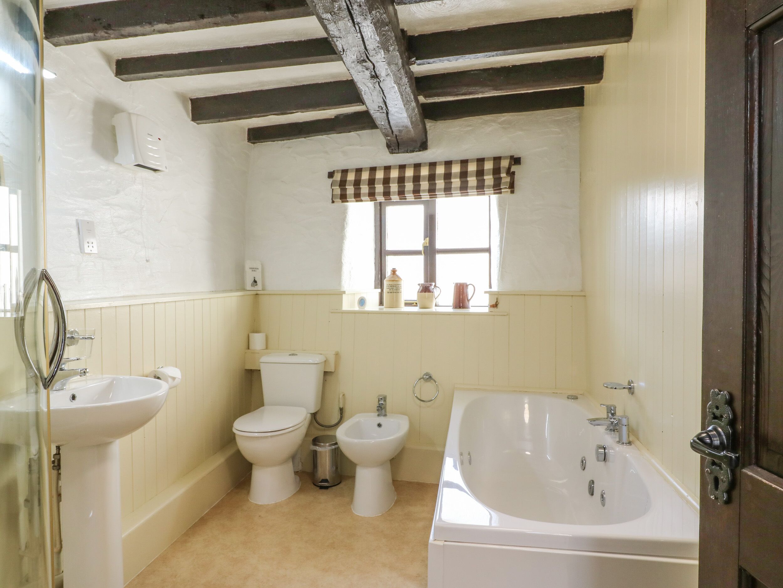 A bathroom with a toilet, bidet, sink, and bathtub.