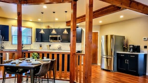 A modern kitchen with a wooden island, stainless steel appliances, and pendant lighting.
