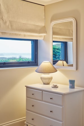 Bathroom features a vanity with drawers, a lamp, and a mirror.