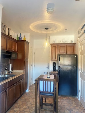 Enjoy cooking in this well-equipped kitchen with a central island, refrigerator, and coffee maker.