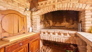 A rustic brick oven with a wooden bench, a wooden cabinet, and a Heineken beer cooler. - 2 bedroom pet friendly home in Hrastovica (Hrastovica)