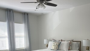 A bedroom with a bed, ceiling fan, bedside lamps, and a window with curtains. - Oxford Townhouse Minutes from campus! (Oxford)