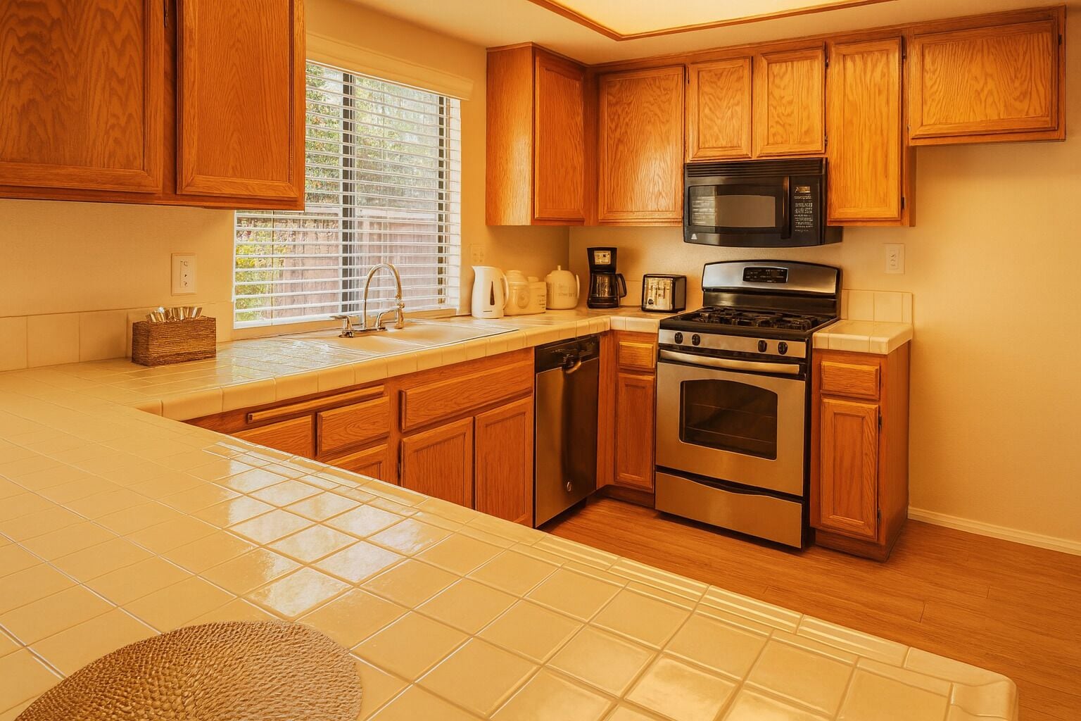 A kitchen with wooden cabinets, a stainless steel stove, a microwave, and a dishwasher.