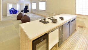 A modern kitchen with a large island, built-in dishwasher, and wooden flooring. - Yuigahama Chiyo (Kamakura)