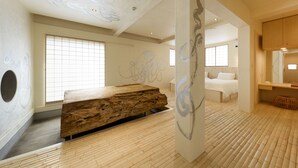 A modern interior with a wooden reception desk, large windows, and a minimalist design. - Yuigahama Chiyo (Kamakura)