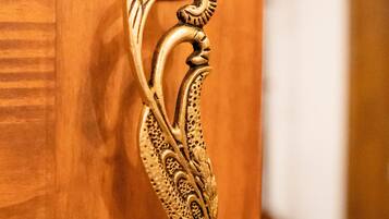 A wooden door with an ornate brass handle featuring a swan design.