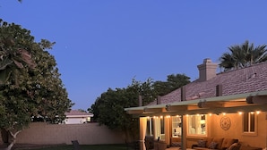 A swimming pool with a hot tub, outdoor seating, and a covered patio area. - Warm and inviting home centrally located. (La Quinta)