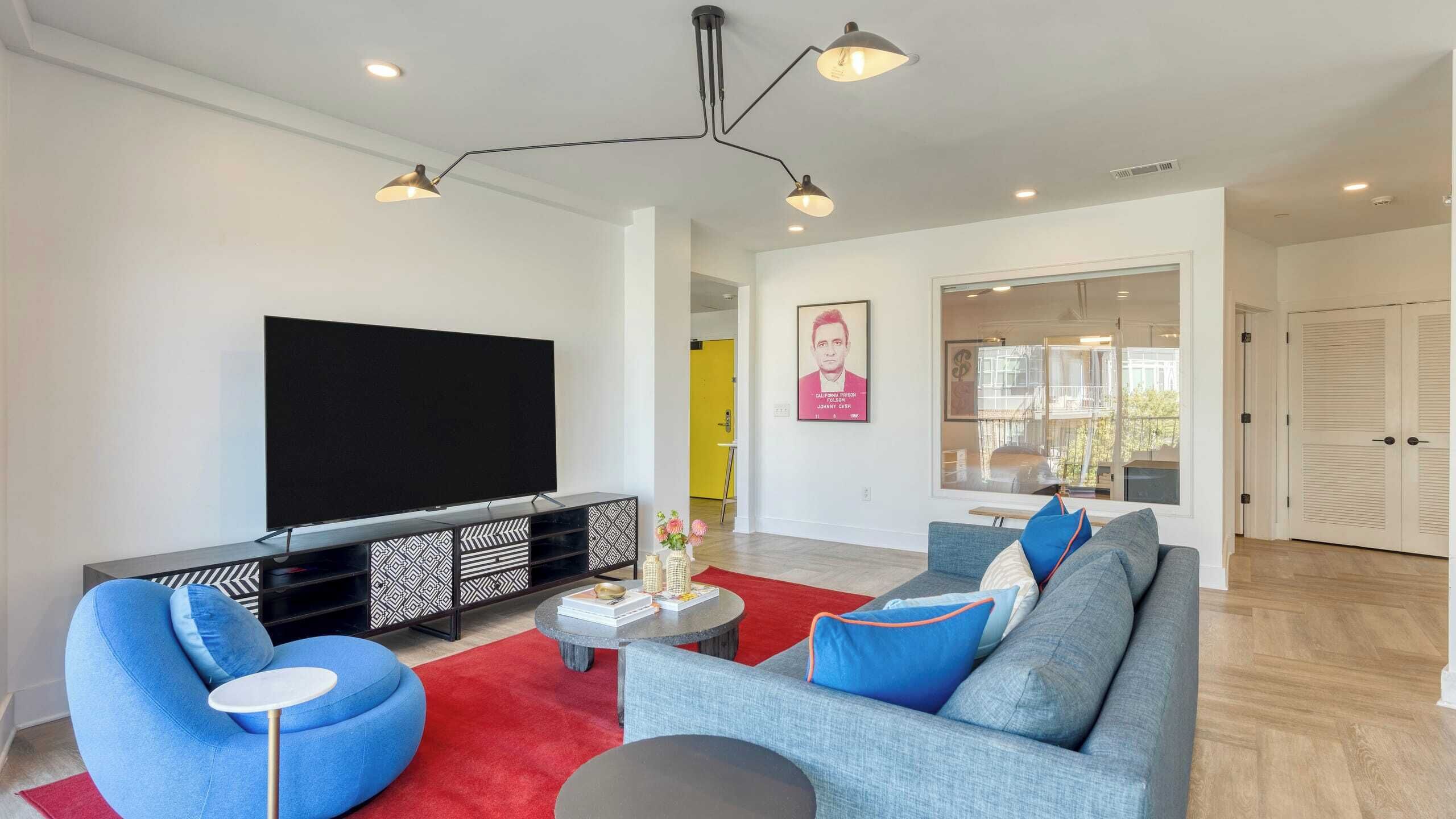 A modern living room with a flat-screen TV, a sofa set, and a coffee table.