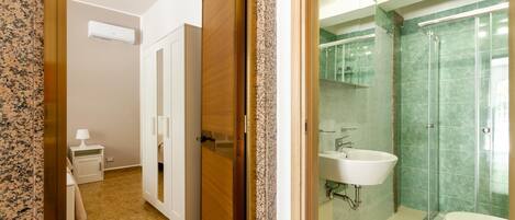 Une salle de bain avec une douche à parois de verre, un lavabo et des toilettes.