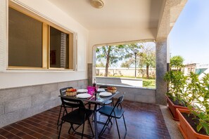 A covered patio with a table set for dining, chairs, and potted plants. - 2903 Residence Mareluna - Bilo 1 by Barbarhouse (Porto Cesareo)