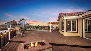 A deck with a fire pit, outdoor furniture, and a pergola with string lights. - Hilltop Wine Estate- Pickleball | Pool | 360 views (Temecula)