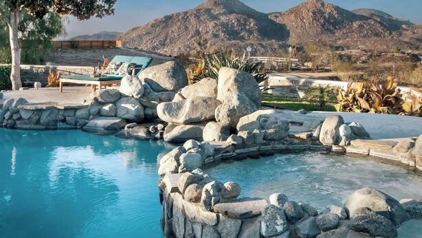A pool with large rocks, lounge chairs, and mountains in the background. - Hilltop Wine Estate- Pickleball | Pool | 360 views (Temecula)