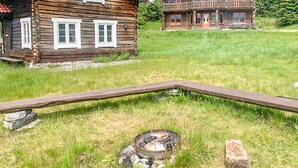 A rustic cabin with a wooden deck and a fire pit in the foreground. - 2 bedroom gorgeous home in Eggedal (Eggedal)