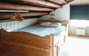 A wooden bunk bed with a sloped ceiling, a window with a view, and a radiator. - 2 bedroom gorgeous home in Eggedal (Eggedal)