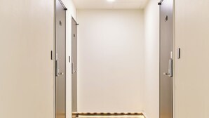 A hallway with two doors, a ceiling light, and a strip of lights along the floor. - K9 Myeongdong Seoul (Seoul)
