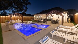Un giardino con piscina, sedie a sdraio e un patio coperto.