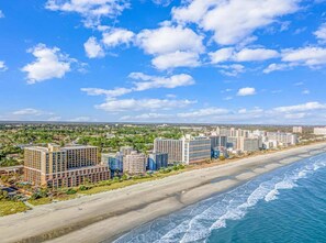 A coastal hotel with multiple buildings, beachfront location, and a view of the ocean.