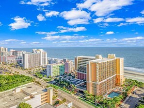 A coastal cityscape with high-rise buildings, a beach, and a clear sky. - Caravelle 619 (Myrtle Beach)