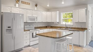 A modern kitchen with white cabinetry, a granite countertop, and a built-in oven. - Peaceful Cul-De-Sac Home, 1 Min. Drive To Zoo MT! (Billings)