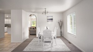 A dining area with a round table and chairs, a chandelier, and a window with blinds. - Peaceful Cul-De-Sac Home, 1 Min. Drive To Zoo MT! (Billings)