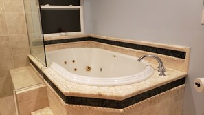 A bathroom with a freestanding bathtub, a glass shower enclosure, and a tiled floor. - For Family Gathering and Celebrate (Beaverton)