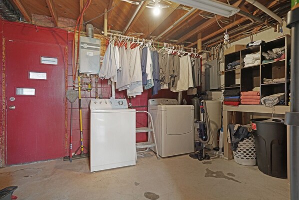 A laundry room with a washing machine, dryer, and clothes drying rack.