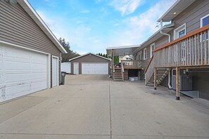 A residential area with two garages, a covered outdoor area, and a staircase leading to a deck.