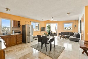 A spacious living area with a dining table, sofa, and kitchen area with modern appliances.