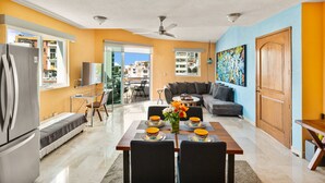 A modern apartment with a dining area, kitchen, and living room.