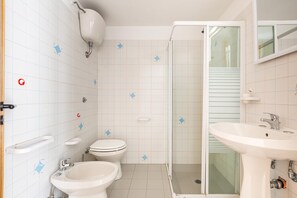 A bathroom with a toilet, bidet, sink, and shower. - 2705 Residence Calipso - Nautilus by Barbarhouse (Porto Cesareo)