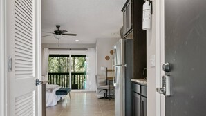 A modern kitchen with a refrigerator, a door with a lock, and a ceiling fan. - Queen Studio | Full Kitchen, Screened Balcony | 1 Small Dog | Ravines (Middleburg)