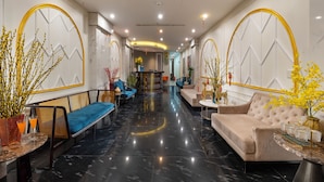 A modern lobby with a marble floor, seating areas, and decorative plants. - Hanoi Fiesta Grand Hotel (Hanoi)