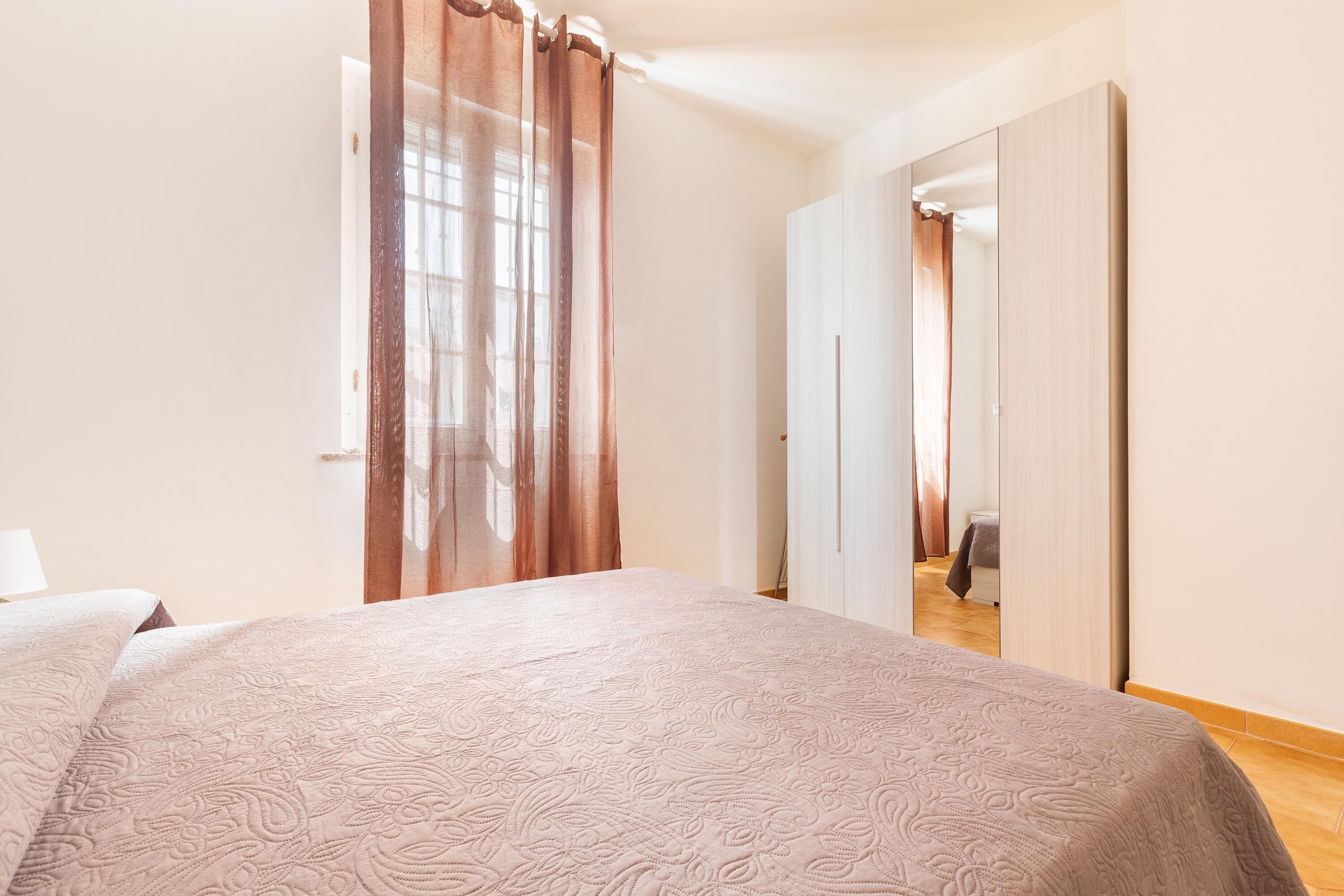 Ein Schlafzimmer mit einem großen Bett, einem Kleiderschrank und einem Spiegel.