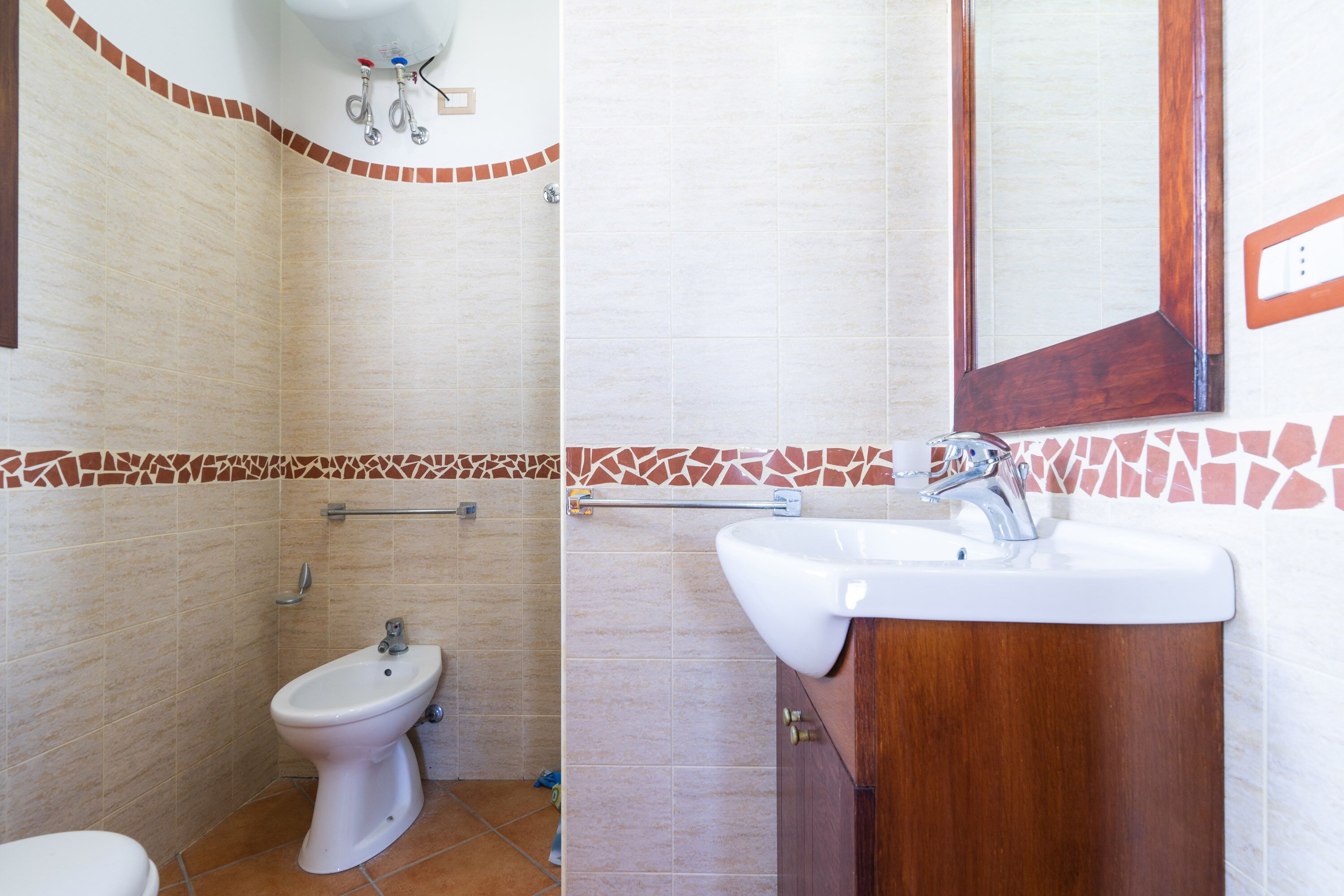 A bathroom with a toilet, bidet, and sink.