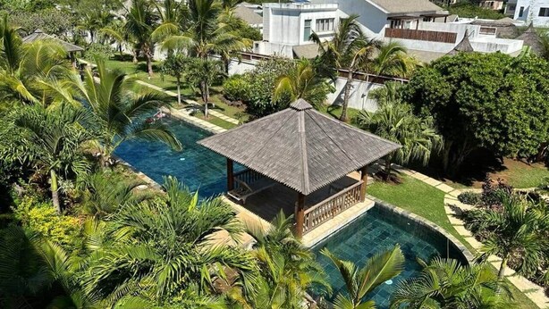 A residential area with a swimming pool, a gazebo, and lush greenery. - Penthouse avec Jacuzzi Privé à Pereybère (Grand Baie)