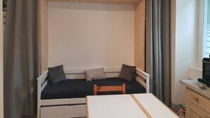 A compact room with a bed, a small table, and a TV. - Renovated central studio, 50 m from cable car, 2-4 pers (Cauterets)