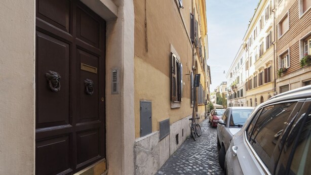 Un carrer empedrat i estret, amb edificis a ambdós costats, una bicicleta aparcada i un cotxe.