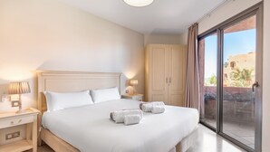 A hotel room with a large bed, bedside lamps, a wardrobe, and a sliding glass door to a balcony. - Bahia - Bencomo 1.2 PARTIAL SEA VIEW & NATURE RESERVE 1B (Arona)