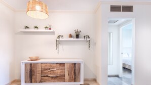 A modern interior with a wooden console, white shelves with plants, and a hanging light fixture. - Bahia - Bencomo 1.2 PARTIAL SEA VIEW & NATURE RESERVE 1B (Arona)
