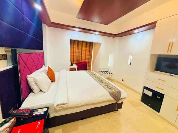 A hotel room with a bed, a TV, a desk, and a chair. - The Elite Residence Dhaka. (Dhaka)