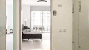 A hallway leading to a living area with a sofa and a coffee table. - Luxury 3BR 32 Floor SeaView (Bat Yam)
