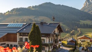 A traditional chalet with a sloped roof, solar panels, and a view of a mountainous landscape. - Apartment Pölvenblick - House Rabl (Itter)