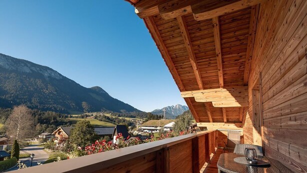 A wooden balcony with a view of a mountainous landscape. - Apartment Pölvenblick - House Rabl (Itter)